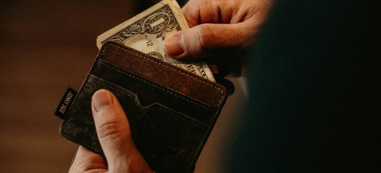5 Hidden Costs of Moving in Cincinnati 3 Person taking out money to pay for the hidden costs of moving
