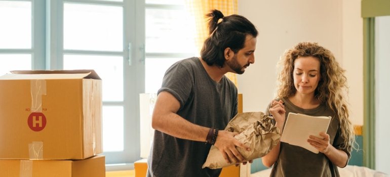 Top 5 Mistakes to Avoid When Moving in Cincinnati 1 two people packing and talking about mistakes to avoid when moving in Cincinnati