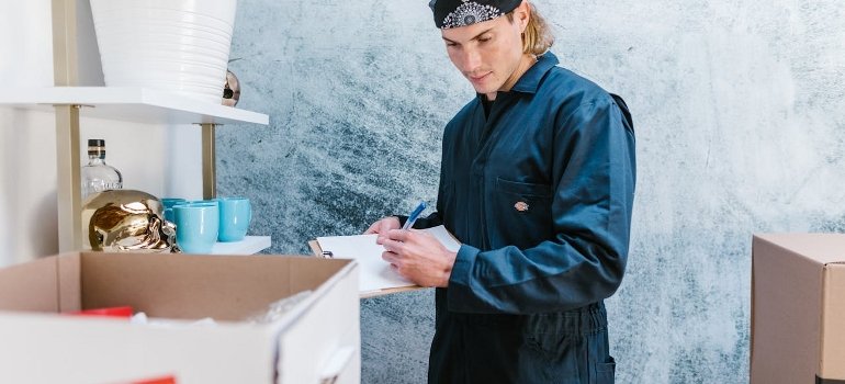 The Ultimate Moving Checklist for Relocating to Cincinnati 3 A professional mover is creating the inventory by following the ultimate moving checklist.
