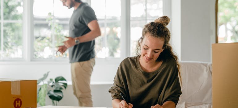 How to Downsize Your Belongings Before Moving to Cincinnati 5 a woman writing in a pad