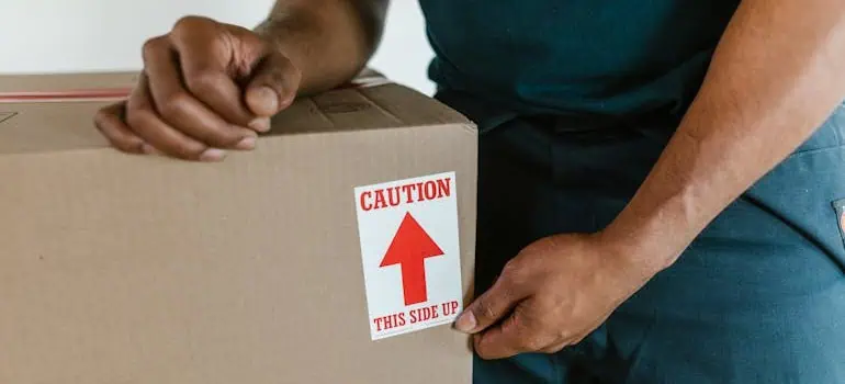 The Ultimate Office Move Checklist for Ohio Businesses 2 expert movers following the office move checklist and taping the box correctly