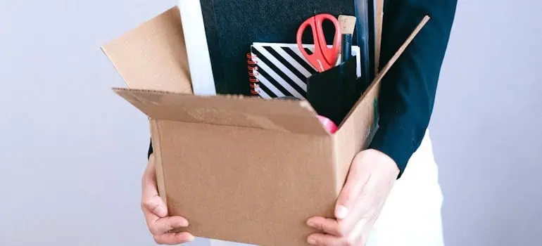 The Ultimate Office Move Checklist for Ohio Businesses 1 person holding a box full office supplies