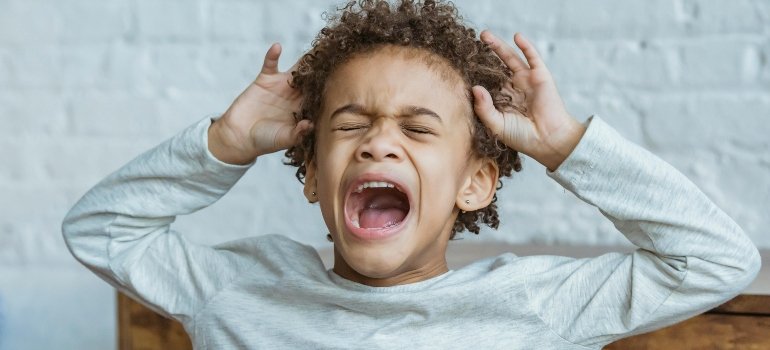 Moving With Kids To Loveland Ohio: What to Expect 1 Desperate screaming young boy during a move, representing the emotional challenges of moving with kids.