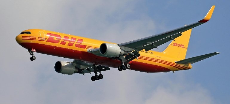 Moving For a Job in Maineville Ohio: Is It Worth It 1 DHL yellow airplane flying in the sky, symbolizing the company’s strong presence and growing opportunities for those moving for a job.