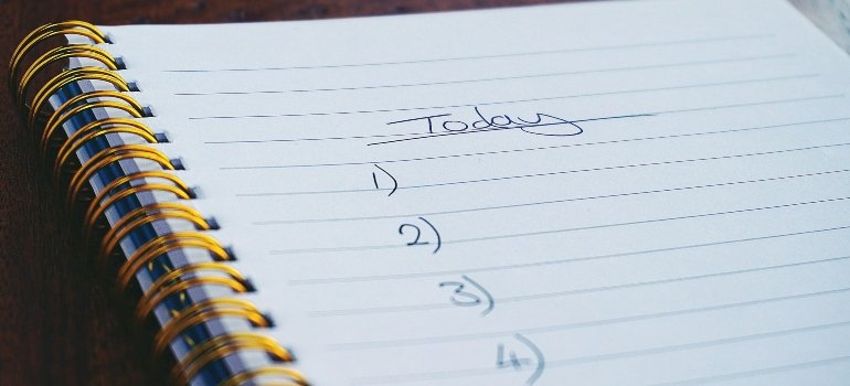 How To Make Moving Less Stressful 1 a notebook with a written checklist for today as one way to learn how to make moving less stressful.