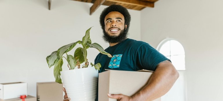 Tips For Moving With Plants Long-Distance 3 Professional mover carefully handling plants during a long-distance move with plants.