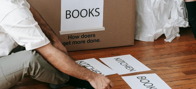 Tips for Moving to a New City Alone 2 Person making labels for moving boxes during the packing process