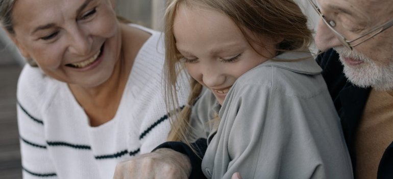 Tips for Moving to a Senior Living Cincinnati Ohio Facility 2 Three people sit close together, sharing a moment, wearing cozy attire