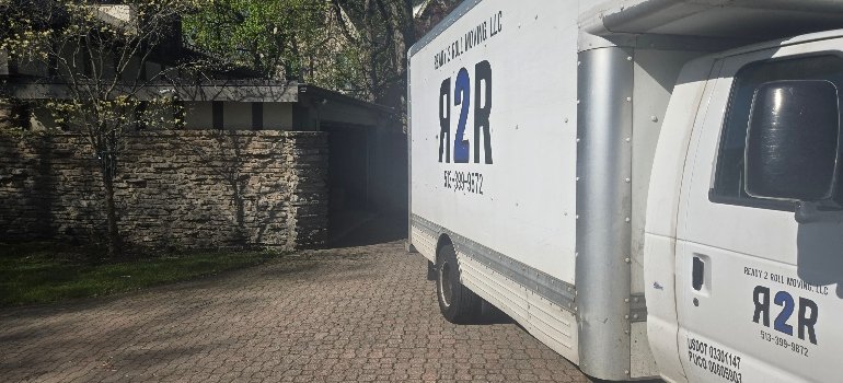 Piano Movers 3 A white truck parked in front of a residential house on a clear day.
