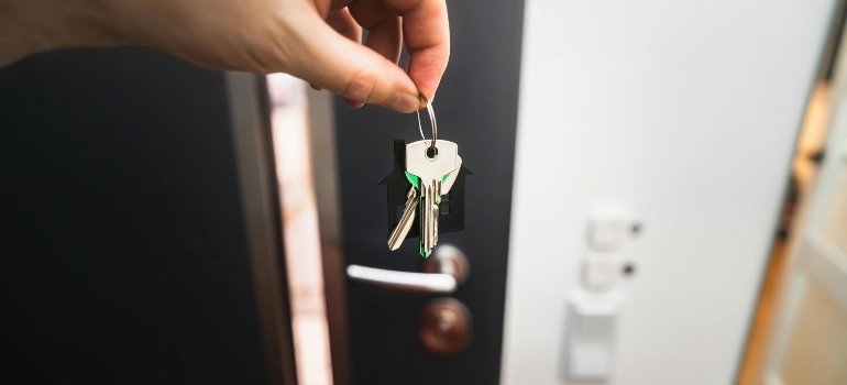 Is Blue Ash OH a Good Place to Live? Cost, Safety, and Neighborhood Guide 2 Hand holding a set of keys in front of an open door, symbolizing a move to Blue Ash and the question is Blue Ash a good place to live.