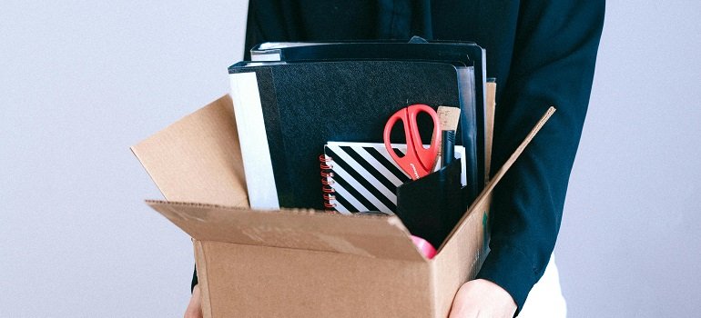 How to Move Your Office Across State Lines Without Interrupting Business 2 a person carrying a box full of office supplies