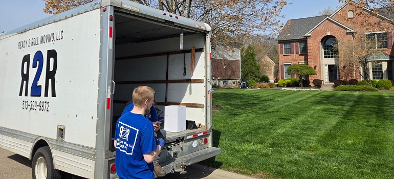 Challenges of moving to Milford OH and how to handle them 4 Mover unloading items from truck in suburban neighborhood