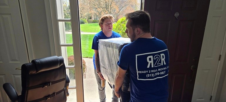 Morrow Movers 3 two movers in morrow carrying a large box out of the house