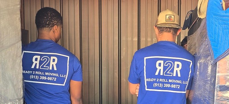 Harrison Movers 3 two professional Harrison movers packing some items into a cardboard box.