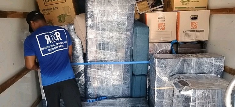 Challenges of moving to Milford OH and how to handle them 7 Mover securing wrapped furniture while moving to Milford OH
