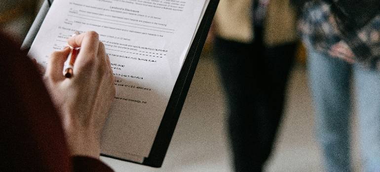 Essential corporate relocation guide for Fairfield OH companies 2 Employee filling checklist on relocation planning clipboard