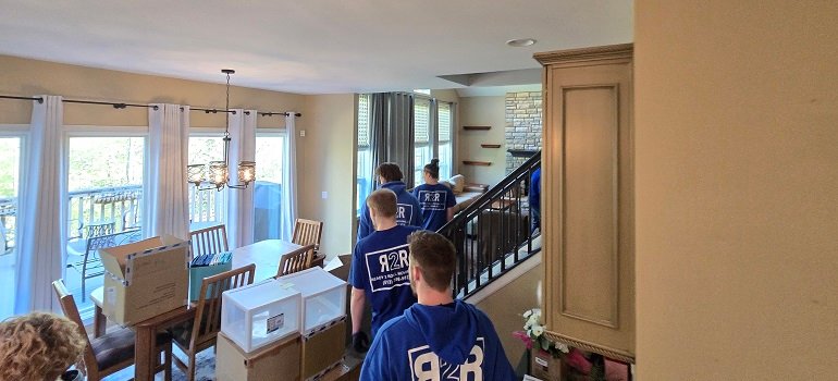 4 easy items to get rid of before moving 1 Moving crew walking through packed home with boxes