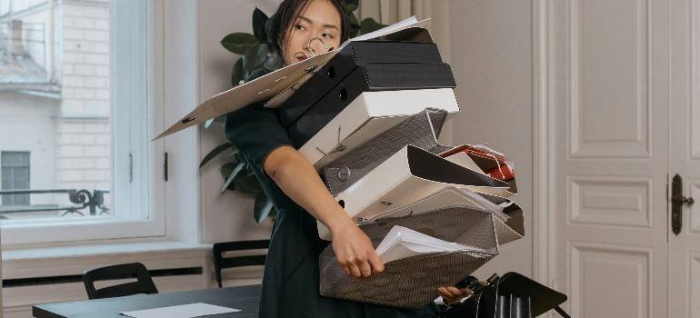 Do you love your clutter? 2 Overwhelmed woman carrying folders, asking herself do you love your clutter