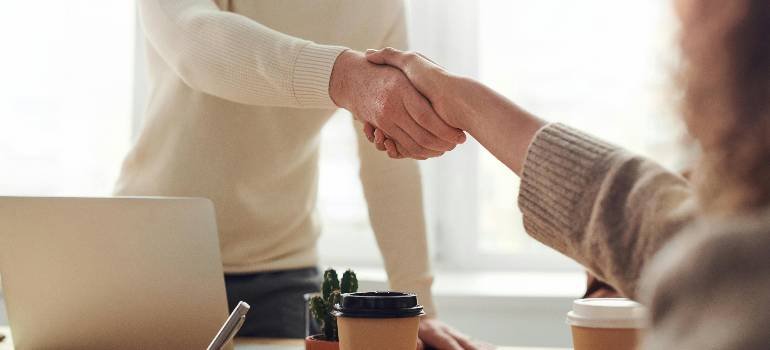 A comprehensive guide for families moving to Hamilton OH 4 Business partners shaking hands over coffee shop table