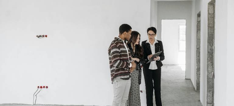 A comprehensive guide for families moving to Hamilton OH 1 Families moving to Hamilton OH touring unfinished home with real estate agent