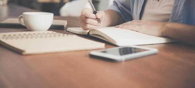 Top places in the Greater Cincinnati metro area for young professionals 4 Person planning relocation with notebook, coffee, and phone