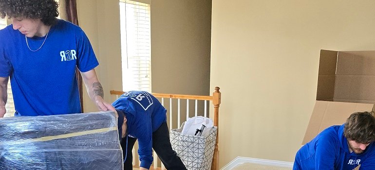 Spring cleaning in Loveland Ohio: Room-by-room checklist 1 Professional movers wrapping furniture in an upstairs hallway.