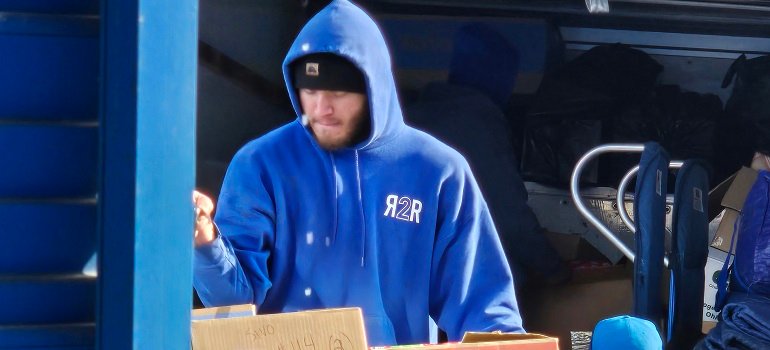 Maximizing daylight during your February move: Tips for a smooth transition 6 Mover in blue hoodie loading packed truck