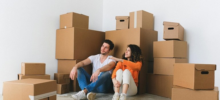 Maximizing daylight during your February move: Tips for a smooth transition 4 Young couple resting on floor among boxes