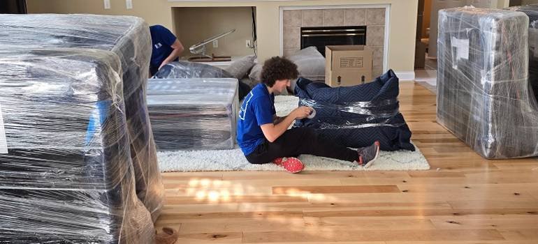 Packing supplies you should never skip for a long distance move 1 Mover wrapping furniture with packing supplies you should never skip